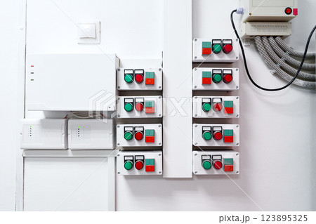 Control panel with multiple switches and indicators installed on the wall in a modern industrial setting Control panel with multiple switches and indicators installed on the wall in a modern industrial setting 123895325