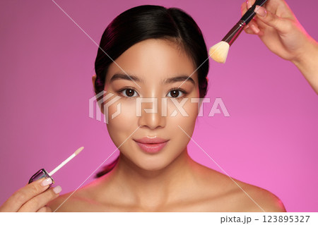 Makeup application on model with radiant skin and professional artistry in a studio setting Makeup application on model with radiant skin and professional artistry in a studio setting 123895327