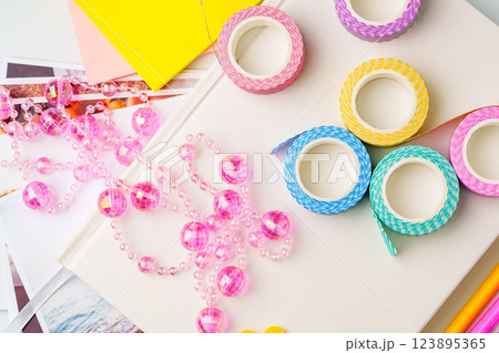 Colorful craft supplies including decorative tape and beads on a creative workspace in daylight Colorful craft supplies including decorative tape and beads on a creative workspace in daylight 123895365