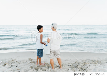 summer vacation at sea. Boy and senior woman at seaside. Grandmother with grandchild are resting on sea, running on beach having fun at summer holiday. Active parents, people activity with children. summer vacation at sea. Boy and senior woman at seaside. Grandmother with grandchild are resting on sea, running on beach having fun at summer holiday. Active parents, people activity with children. 123895463