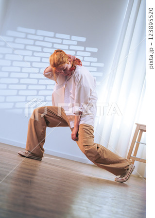 Young dancer performs dynamic move in bright studio space during daytime practice session Young dancer performs dynamic move in bright studio space during daytime practice session 123895520