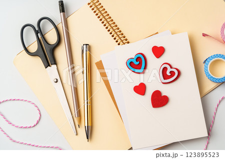 Creative workspace for making handmade greeting cards with colorful hearts and stationery Creative workspace for making handmade greeting cards with colorful hearts and stationery 123895523