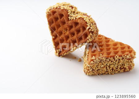 Heart-shaped waffles coated with nuts add a sweet touch to any dessert platter at a cozy cafe 123895560