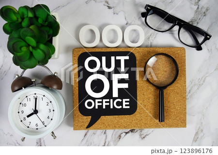 OOO - Out of Office acronym with alarm clock and magnifying glass, business concept background 123896176
