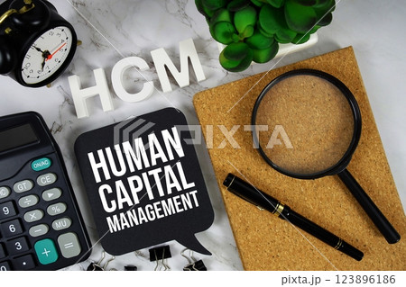 HCM - Human Capital Management acronym with calculator, alarm clock and magnifying glass, Business concept background HCM - Human Capital Management acronym with calculator, alarm clock and magnifying glass, Business concept background 123896186
