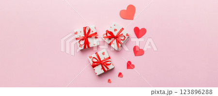 Valentine day composition: red gift box with bow and heart. Christmas present. View from above. Space for text. Holday greeting card 123896288
