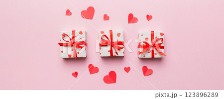 Valentine day composition: red gift box with bow and heart. Christmas present. View from above. Space for text. Holday greeting card Valentine day composition: red gift box with bow and heart. Christmas present. View from above. Space for text. Holday greeting card 123896289