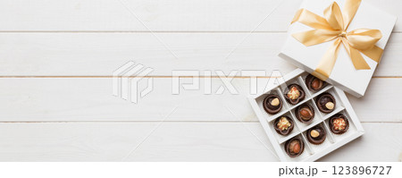 White box with chocolates candies and golden tape. top view with copy space 123896727