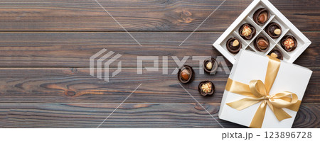 White box with chocolates candies and golden tape. top view with copy space 123896728