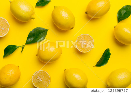 Many fresh ripe lemons as colored background, top view. Elegant background of lemon and lemon slices Top view flat lay 123896737
