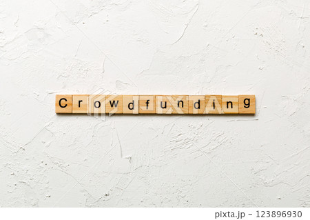 CROWDFUNDING word written on wood block. CROWDFUNDING text on cement table for your desing, concept CROWDFUNDING word written on wood block. CROWDFUNDING text on cement table for your desing, concept 123896930