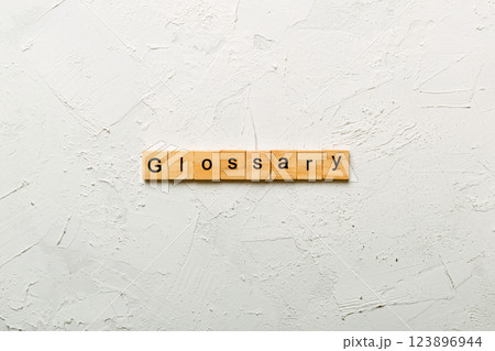 Glossary word written on wood block. Glossary text on cement table for your desing, Top view concept 123896944