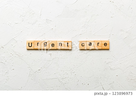 Urgent care word written on wood block. Urgent care text on cement table for your desing, concept Urgent care word written on wood block. Urgent care text on cement table for your desing, concept 123896973