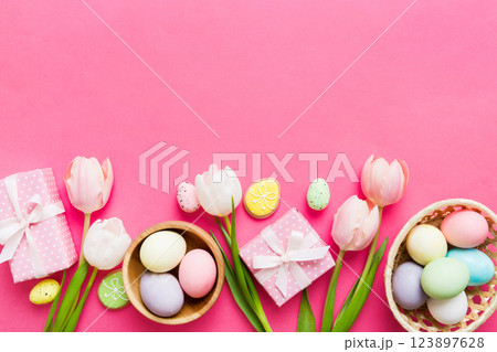 Easter frame with eggs, gift box and tulip on a colored background. The minimal concept. Top view Happy Easter composition. Card with a copy space of the place for the text Easter frame with eggs, gift box and tulip on a colored background. The minimal concept. Top view Happy Easter composition. Card with a copy space of the place for the text 123897628
