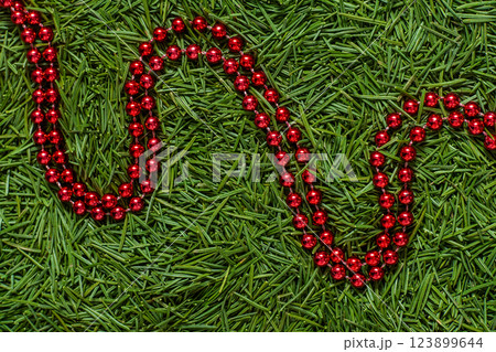 Red Bead Garland on Green Needles background Red Bead Garland on Green Needles background 123899644