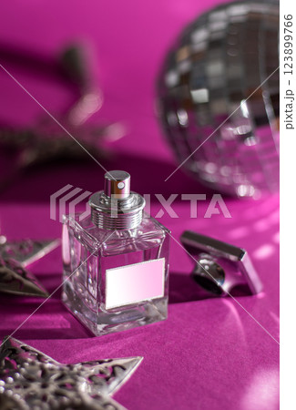 Perfume bottle on a pink background. Eau de toilette concept. Women's perfume in a small glass bottle. Perfumes and fragrances 123899766