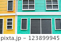 Colorful building facade with wooden panels and white window frames abstract 123899945