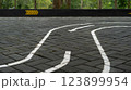 Curved path on brick pavement with directional arrows for guidance 123899954