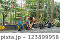 Young boy checking balance bike on outdoor course with flag decorations 123899958