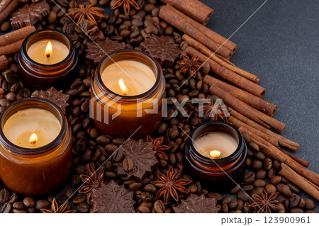 Soy scented candle in a jar. Coffee beans, anise, cinnamon spices. The candles are burning. Soy scented candle in a jar. Coffee beans, anise, cinnamon spices. The candles are burning. 123900961