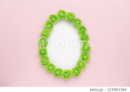 Pastel green rosebuds egg shape on pink background. Versatile Easter-themed composition perfect for backgrounds, greeting cards, social media, and seasonal marketing. 123901364