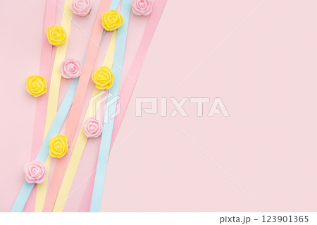 Pastel paper strips and rosebuds on baby pink background. Versatile Easter-themed composition perfect for backgrounds, greeting cards, social media, and seasonal marketing Pastel paper strips and rosebuds on baby pink background. Versatile Easter-themed composition perfect for backgrounds, greeting cards, social media, and seasonal marketing 123901365