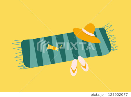Towel with sunscreen, straw hat and flip flops on sand Towel with sunscreen, straw hat and flip flops on sand 123902077
