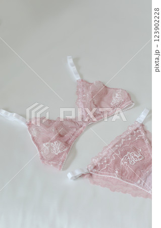 Woman's silk erotic lingerie on the white bed sheets. Valentine's day concept. Lace sexy female underwear. Beauty, fashion blogger concept. Female bra, panties, erotic clothes. Lingerie advertising 123902228