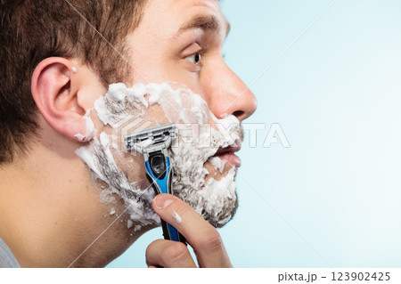 Man shaving with razor face profile Man shaving with razor face profile 123902425