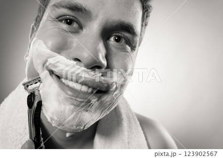Happy man shaving using razor with cream foam. Happy man shaving using razor with cream foam. 123902567