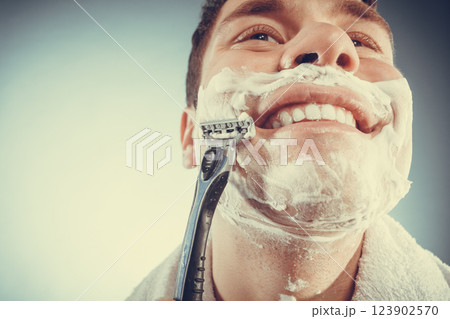 Happy man shaving using razor with cream foam. Happy man shaving using razor with cream foam. 123902570
