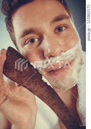 Young man shaving having fun with machete. 123902572