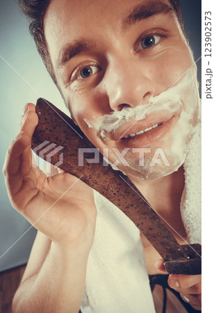 Young man shaving having fun with machete. 123902573