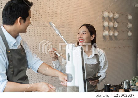 Entrepreneurship and Coffee Shop Experience. Two baristas sharing joyful moments while serving customers in a cozy cafe setting. 123902937