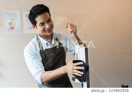 Eco-Conscious Practices in Coffee Making. A barista efficiently cleaning espresso machine equipment in a sustainable coffee shop. 123902958