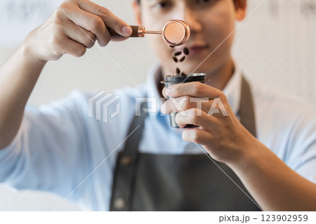 Precise Coffee Handling A barista measuring coffee beans with focus and skill. 123902959