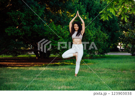 Woman doing yoga fitness asana in the park on the grass Woman doing yoga fitness asana in the park on the grass 123903038
