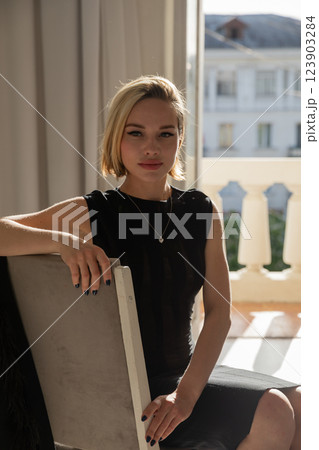 Beautiful slim blonde woman in black evening dress 123903284