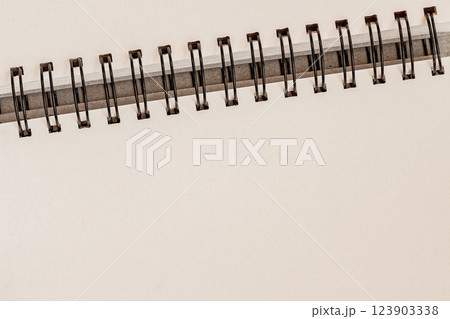Minimalist spiral notebook with blank pages and metal binding. Clean and elegant background for business, education, stationery designs Minimalist spiral notebook with blank pages and metal binding. Clean and elegant background for business, education, stationery designs 123903338