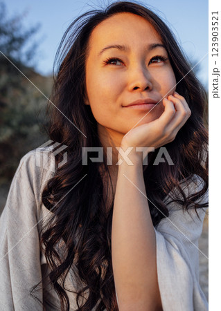 Young attractive Asian with long wavy hair outdoors. A charming Korean woman 123903521