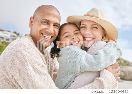 Mom, dad and child hug at the beach on family vacation, holiday and enjoying weekend. Love, affection and multicultural parents with happy girl in portrait smile, bond and embrace by ocean together Mom, dad and child hug at the beach on family vacation, holiday and enjoying weekend. Love, affection and multicultural parents with happy girl in portrait smile, bond and embrace by ocean together 123904433