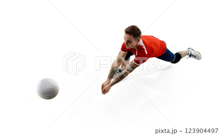 Top view image of concentrated male volleyball player reaching towards ball, training, playing against white studio background 123904497