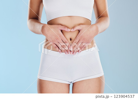 Healthy stomach, heart and woman hands, wellness and gut health, body contouring and diet on studio blue background. Fitness model belly love, digestion and skincare, laser liposuction and abdomen 123904537