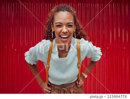 Woman, happy and freedom fashion, smile and outdoor fun on the weekend alone. Portrait of a young female laugh, fashionable and feeling confident while spending her free time on a red background 123904778