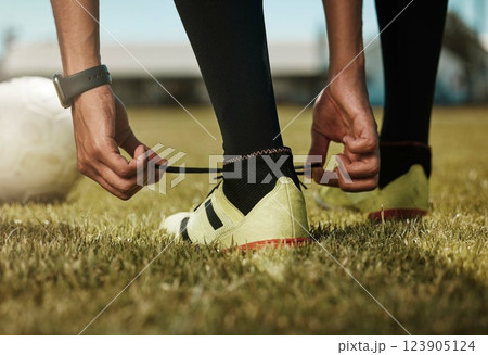 Shoes tie, sports ball and soccer man or athlete on green grass ready for exercise or training. Fitness, workout and game or match of a sport person player before football cardio in nature and summer 123905124