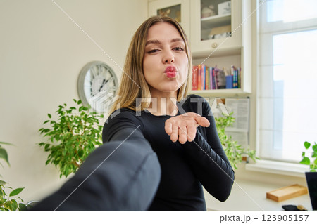 Close-up selfie portrait of young cheerful woman looking at web camera 123905157