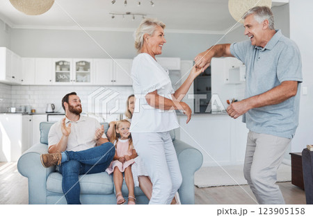 Senior couple dance together for retirement, family or marriage celebration with happiness with kid in background. Elderly pension people dancing to music with love, care and wellness in living room Senior couple dance together for retirement, family or marriage celebration with happiness with kid in background. Elderly pension people dancing to music with love, care and wellness in living room 123905158