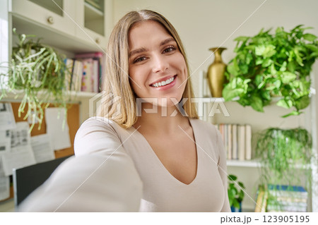 Close-up selfie portrait of young cheerful woman looking at web camera Close-up selfie portrait of young cheerful woman looking at web camera 123905195