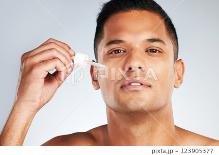 Man beauty, face and health serum oil for glowing, healthy and aesthetic skincare on grey studio background. Portrait young latino model liquid cosmetics product for clean facial skin wellness Man beauty, face and health serum oil for glowing, healthy and aesthetic skincare on grey studio background. Portrait young latino model liquid cosmetics product for clean facial skin wellness 123905377