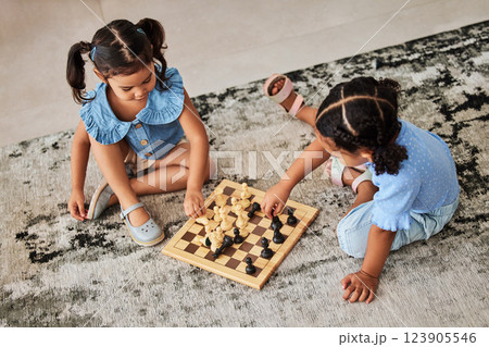 Girl children, knowledge fun and chess game on a living room carpet for home education. Kids in a household for brain development growth, youth problem solving and strategy playing on floor and rug 123905546